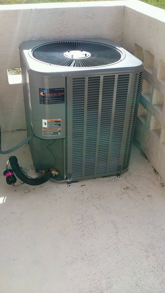 Air conditioning unit on a concrete pad next to a light-colored wall