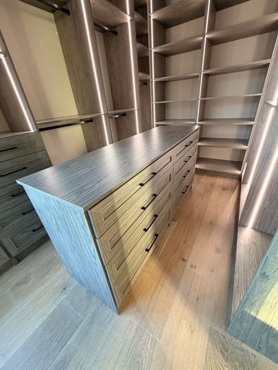 Metal cabinets in a storage unit with shelves lining the walls and a wooden floor.