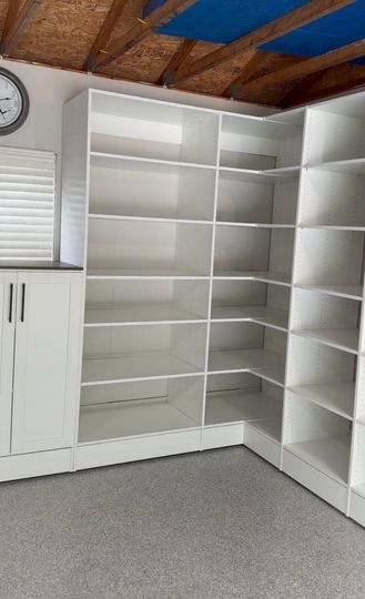 Walk-in closet with light wood cabinets, shelves, and drawers under a ceiling light.