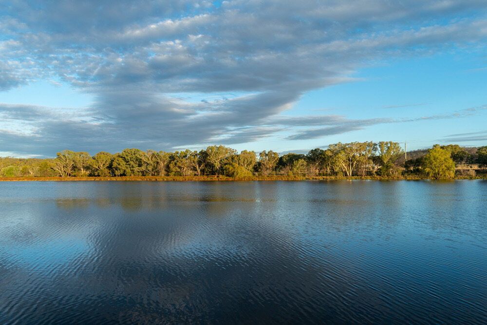 A Large Body of Water Surrounded by Trees on a Cloudy Day — Bull Family Funerals in Inverell, NSW