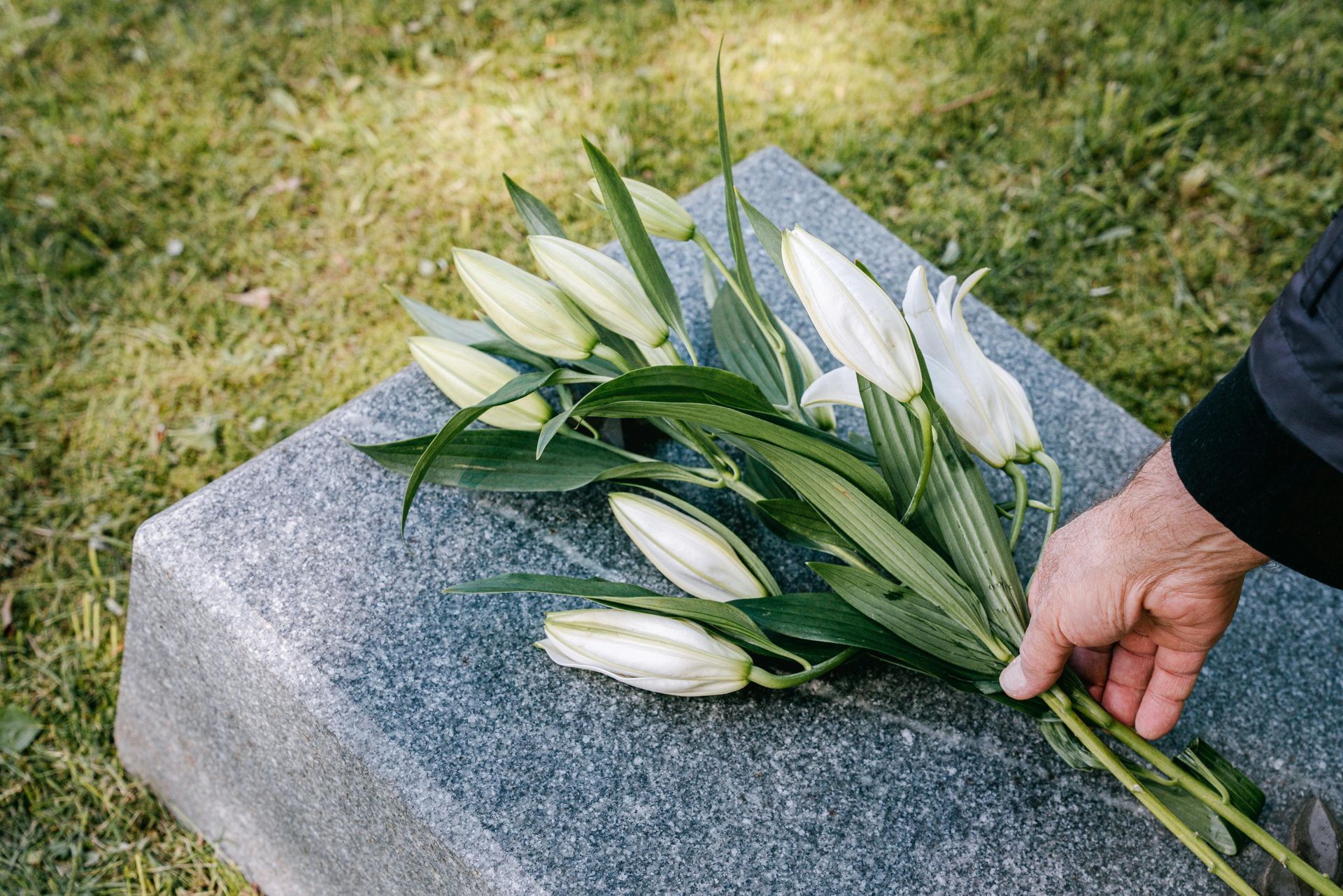 A Bunch of Lit Candles Are Sitting on a Brick Wall — Bull Family Funerals in Inglewood, QLD