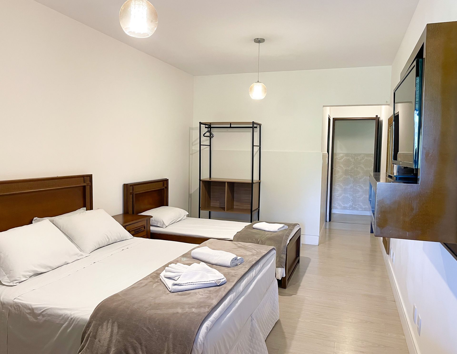 A hotel room with two beds and a flat screen tv.