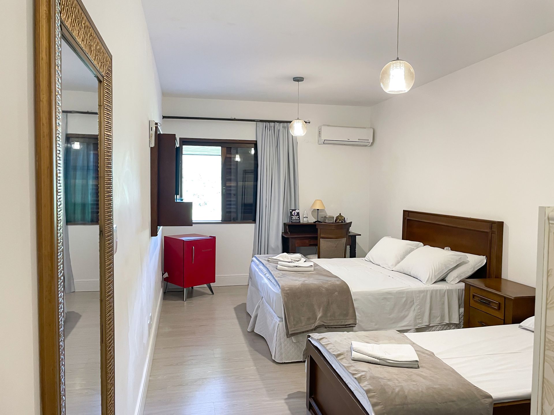 A bedroom with two beds and a large mirror
