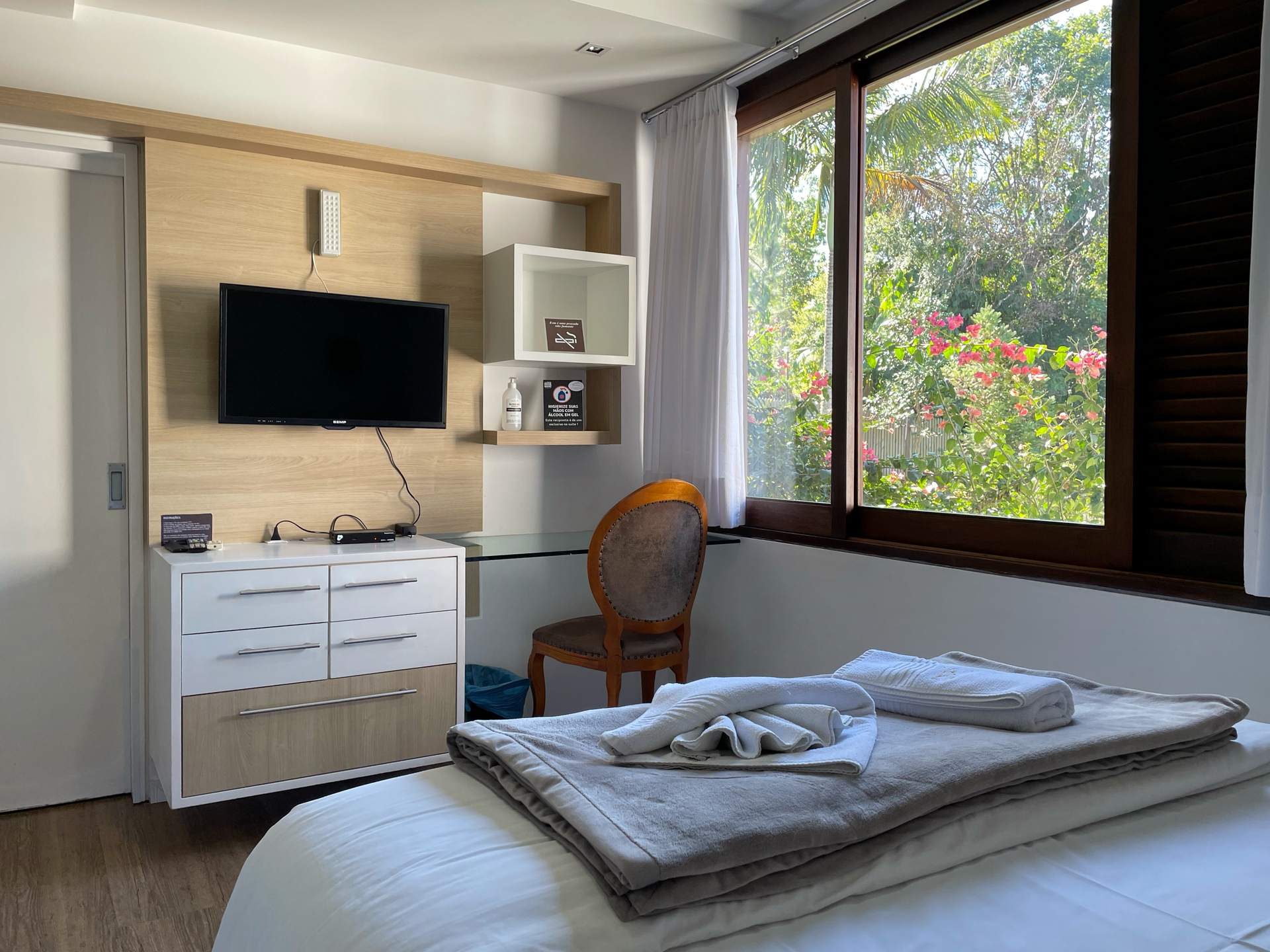 A bedroom with a bed , television , chair and window.
