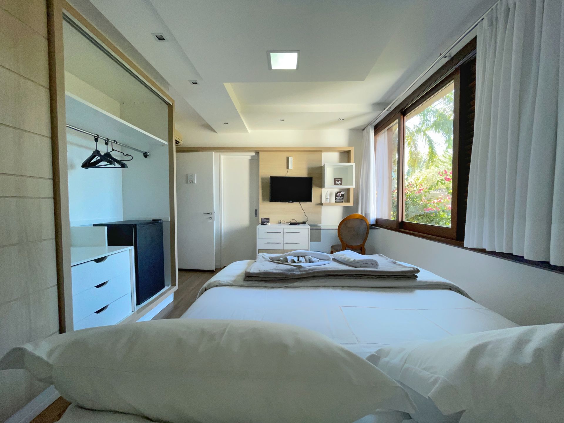 A bedroom with a large bed and a large window