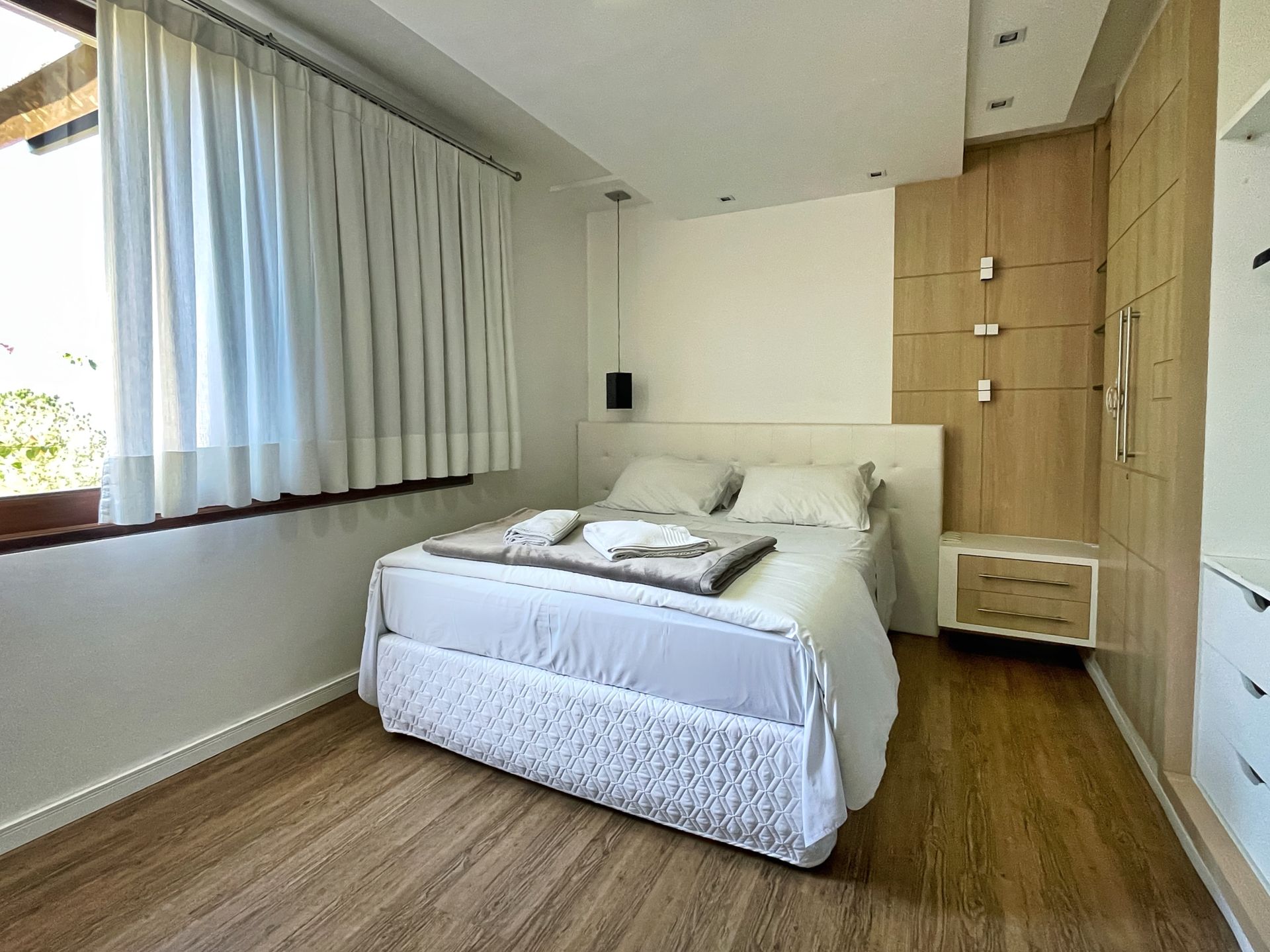A bedroom with a large bed and a window