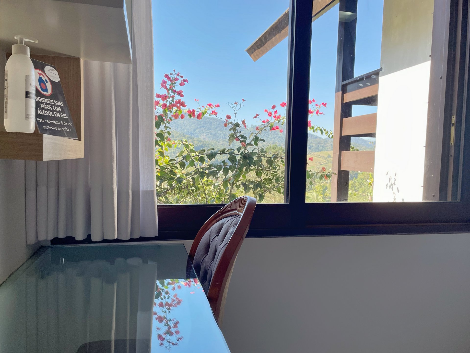 A room with a table and chairs in front of a window.