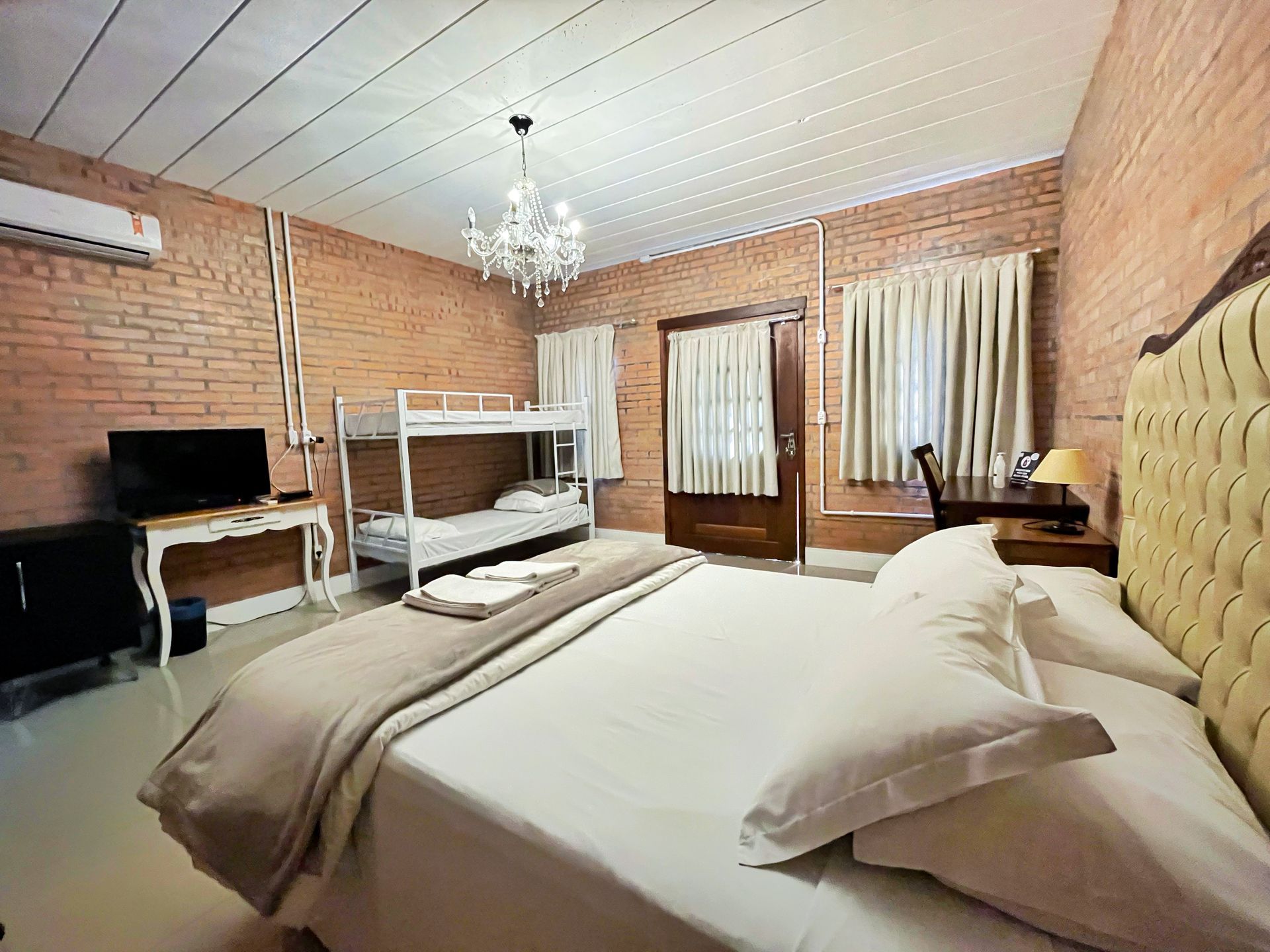 A hotel room with a king size bed and bunk beds.