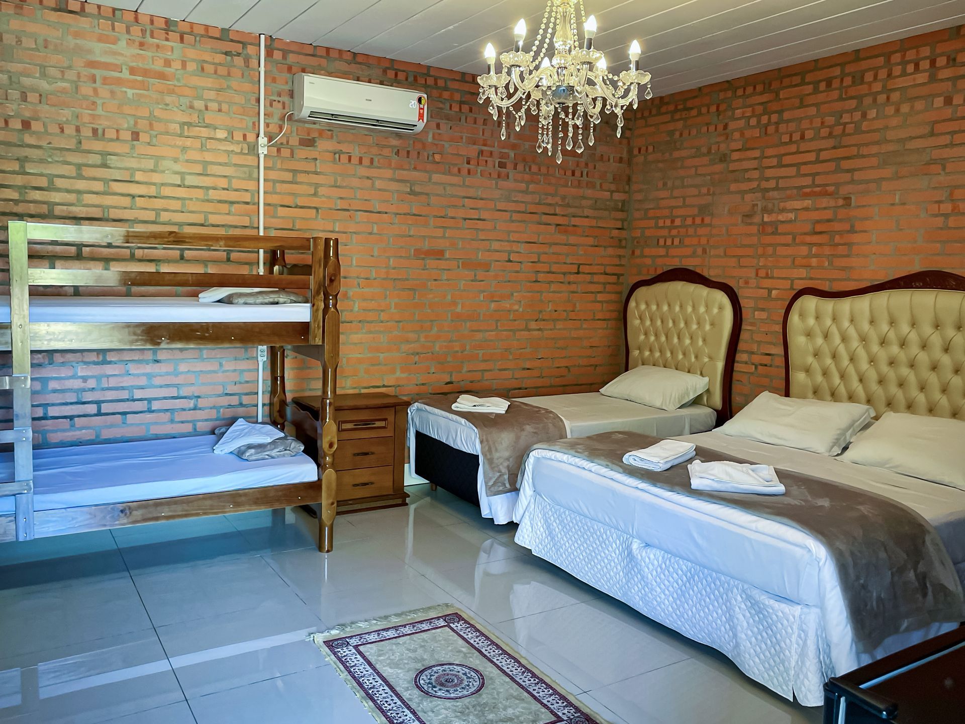 A hotel room with three beds and a bunk bed.