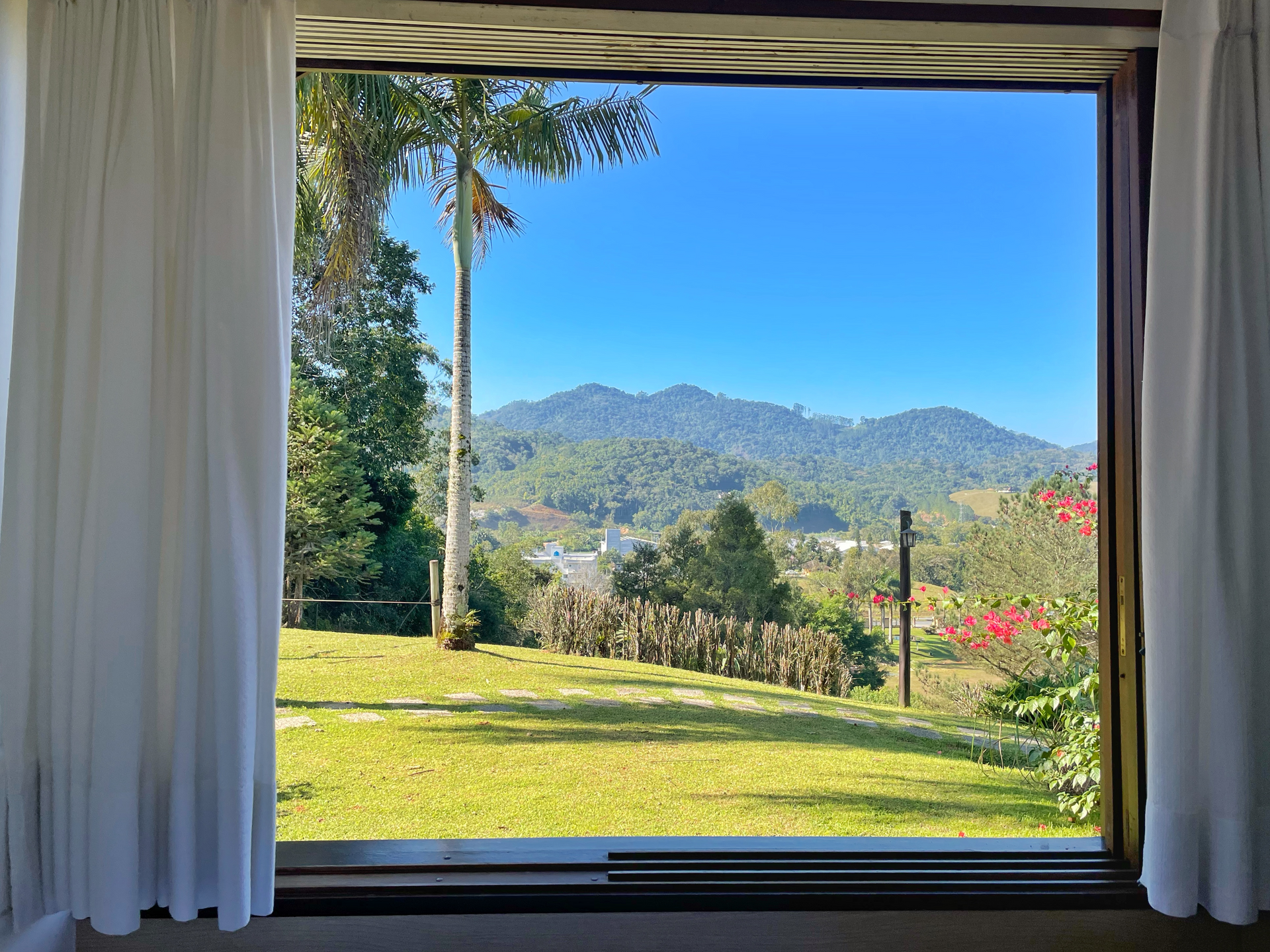 A window with a view of a field and mountains
