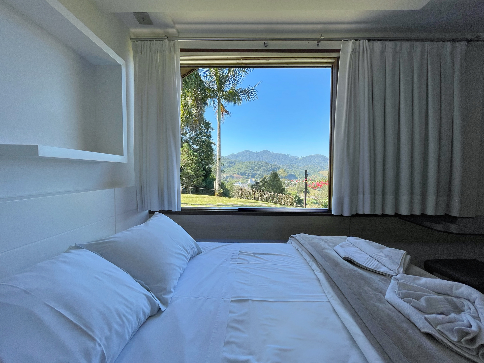 A bedroom with a bed and a window with a view of the mountains.