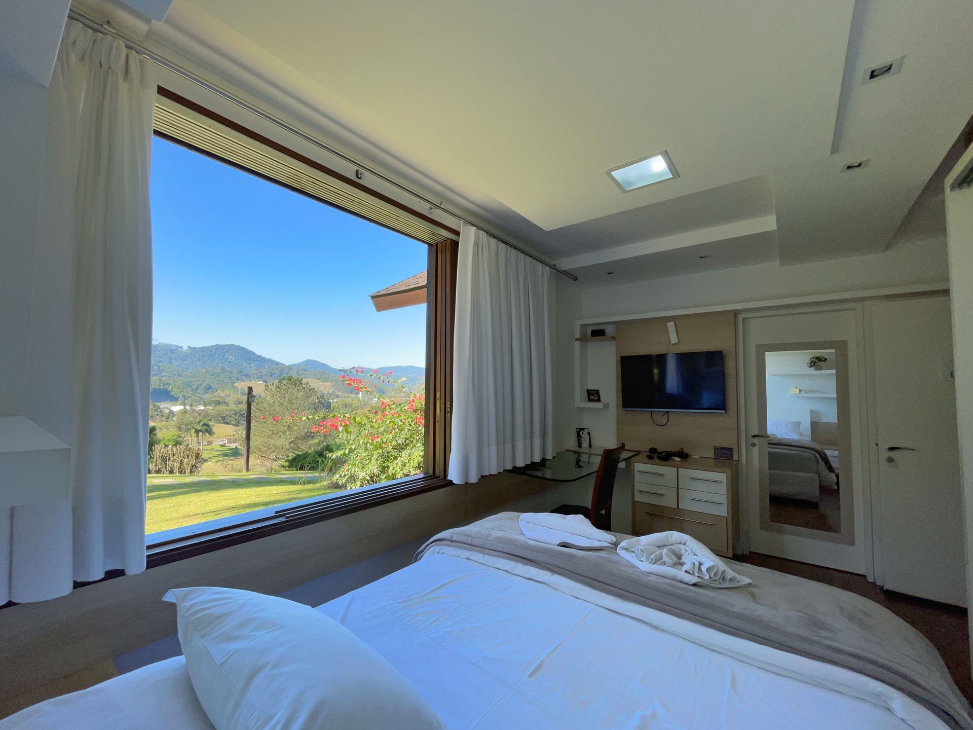 A bedroom with a large bed and a large window.