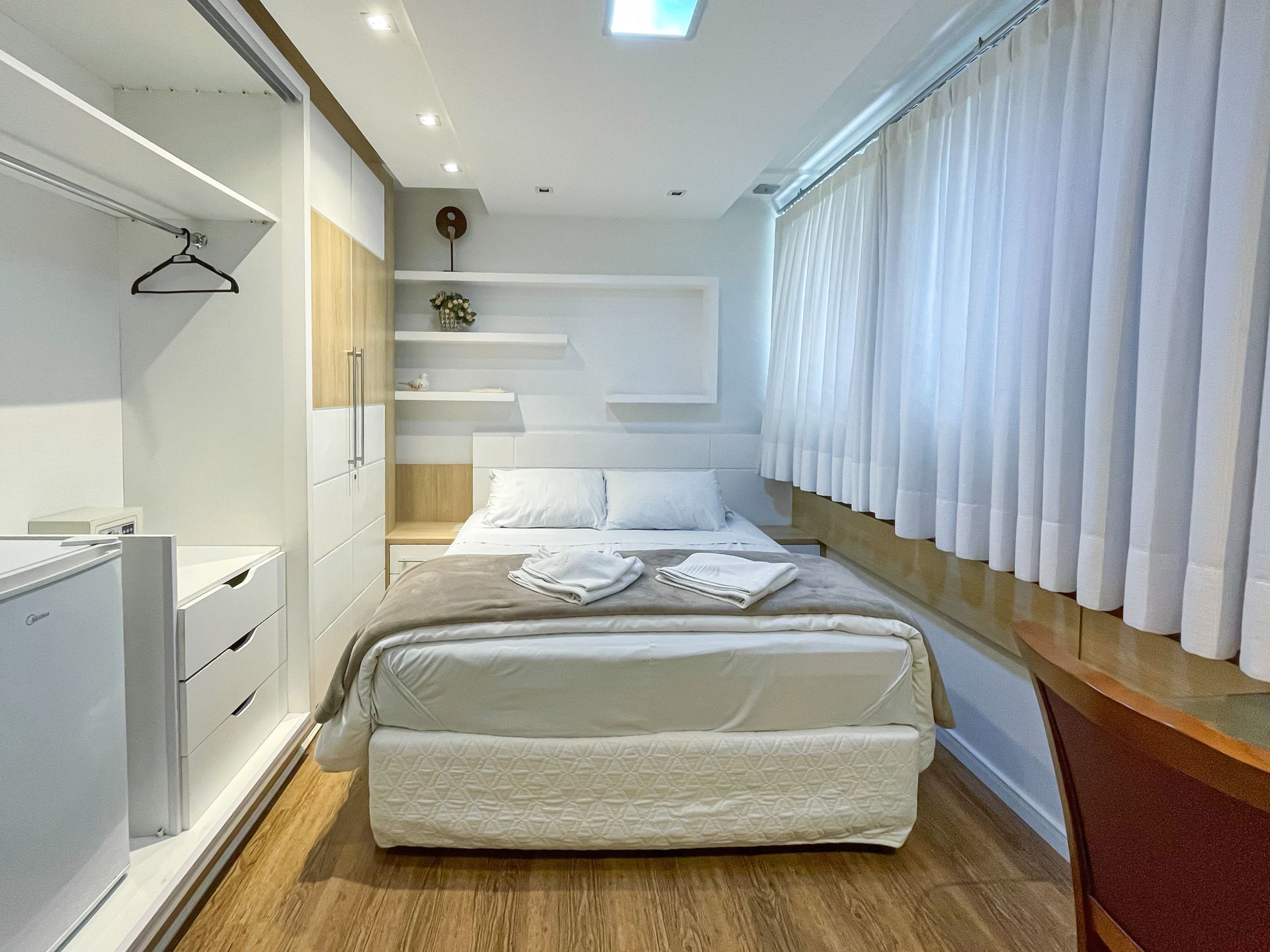 A bedroom with a bed and a desk in it