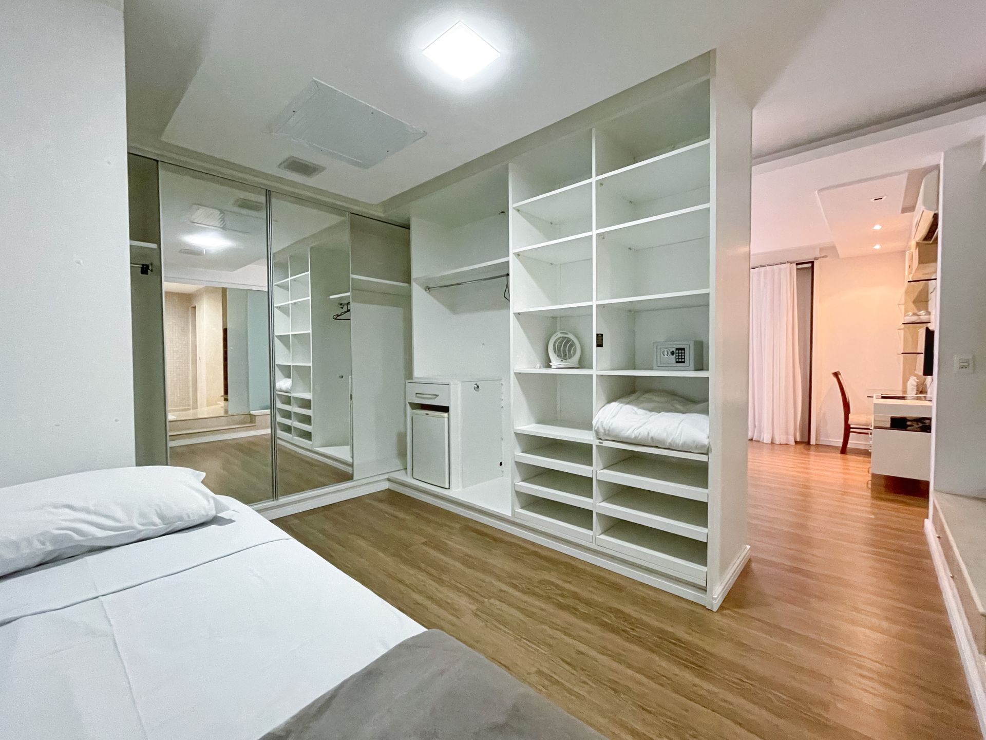 A bedroom with a bed and a walk in closet.
