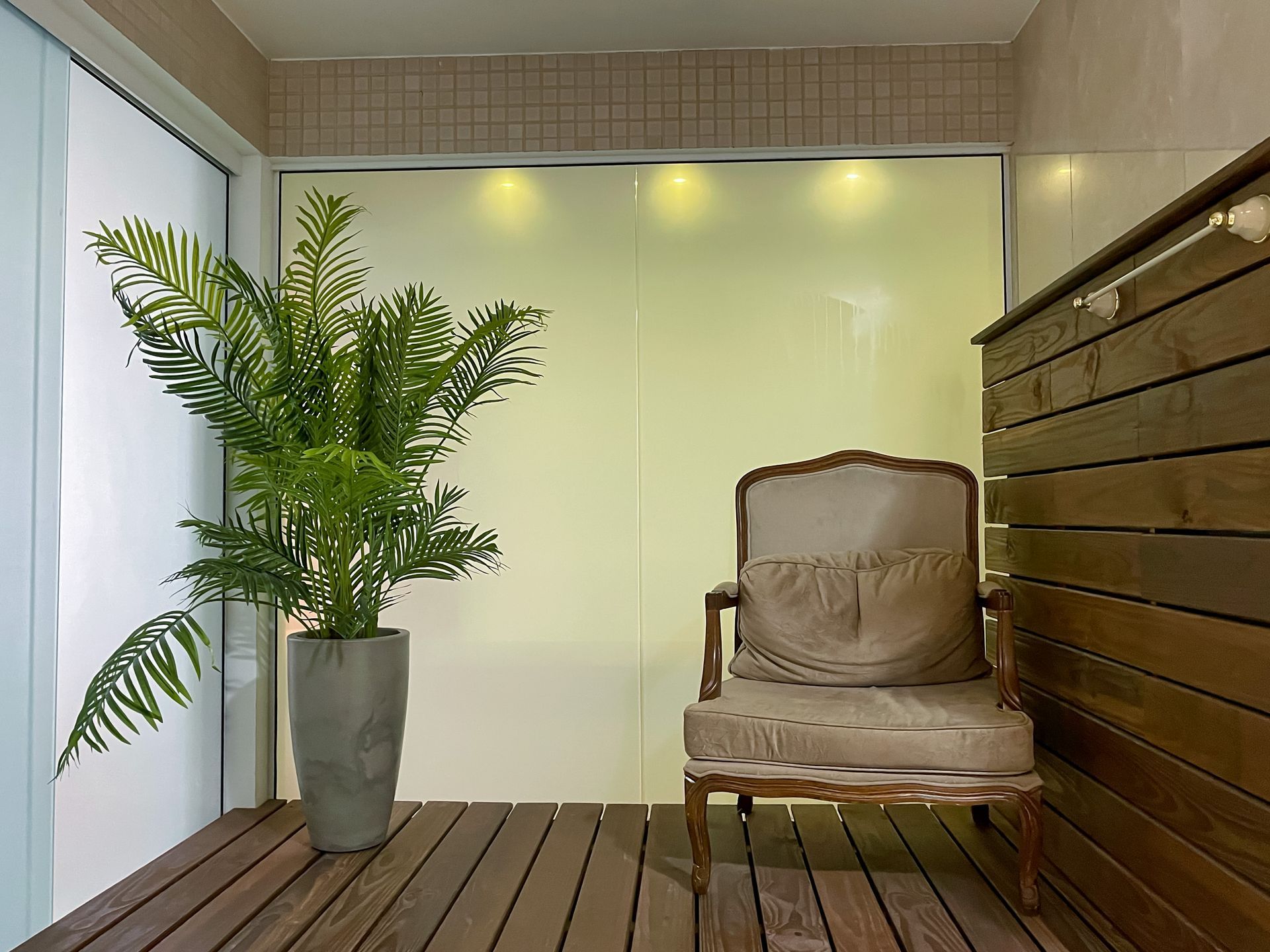 A chair is sitting on a wooden deck next to a potted plant