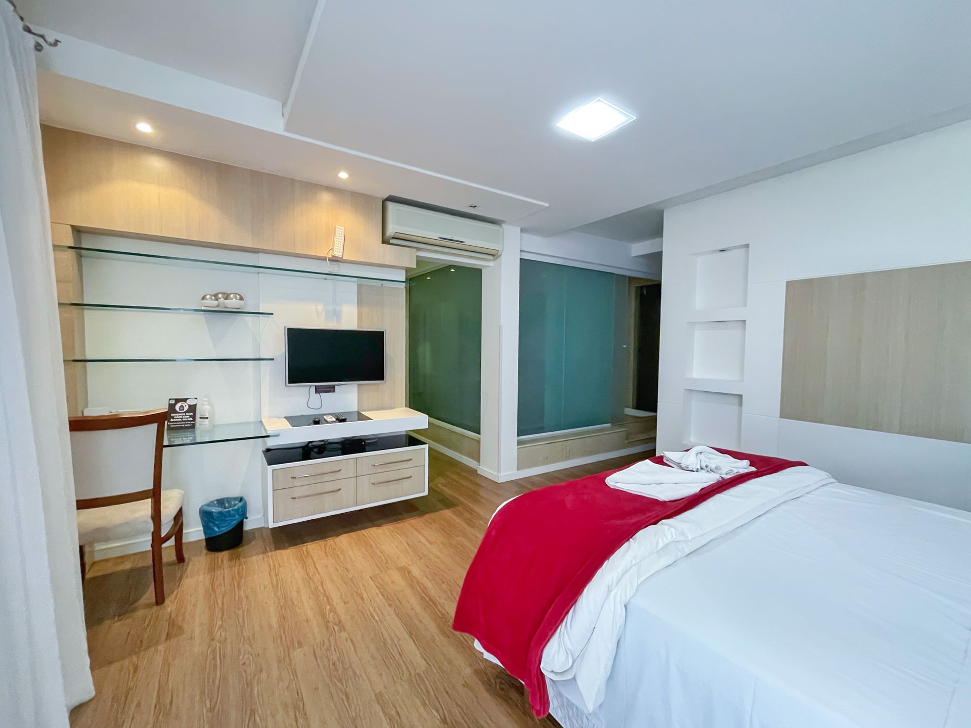 A bedroom with a bed , television , desk and chair.