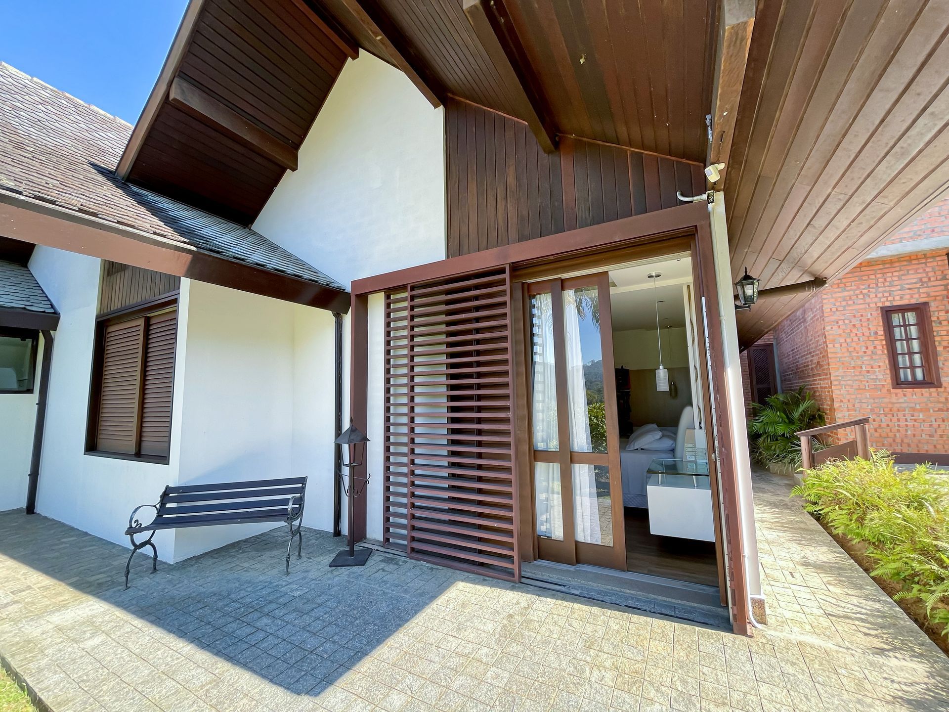 A house with a sliding glass door and a bench in front of it.