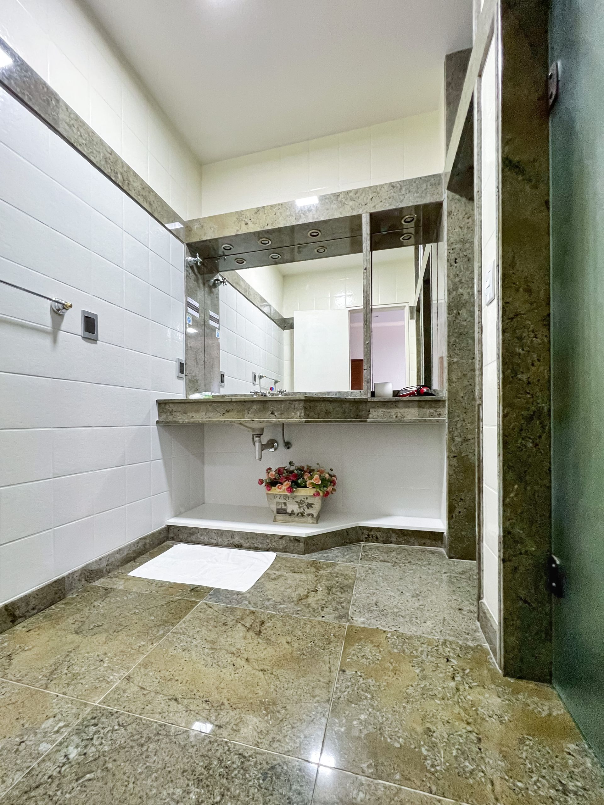 A bathroom with a sink , mirror and shower.