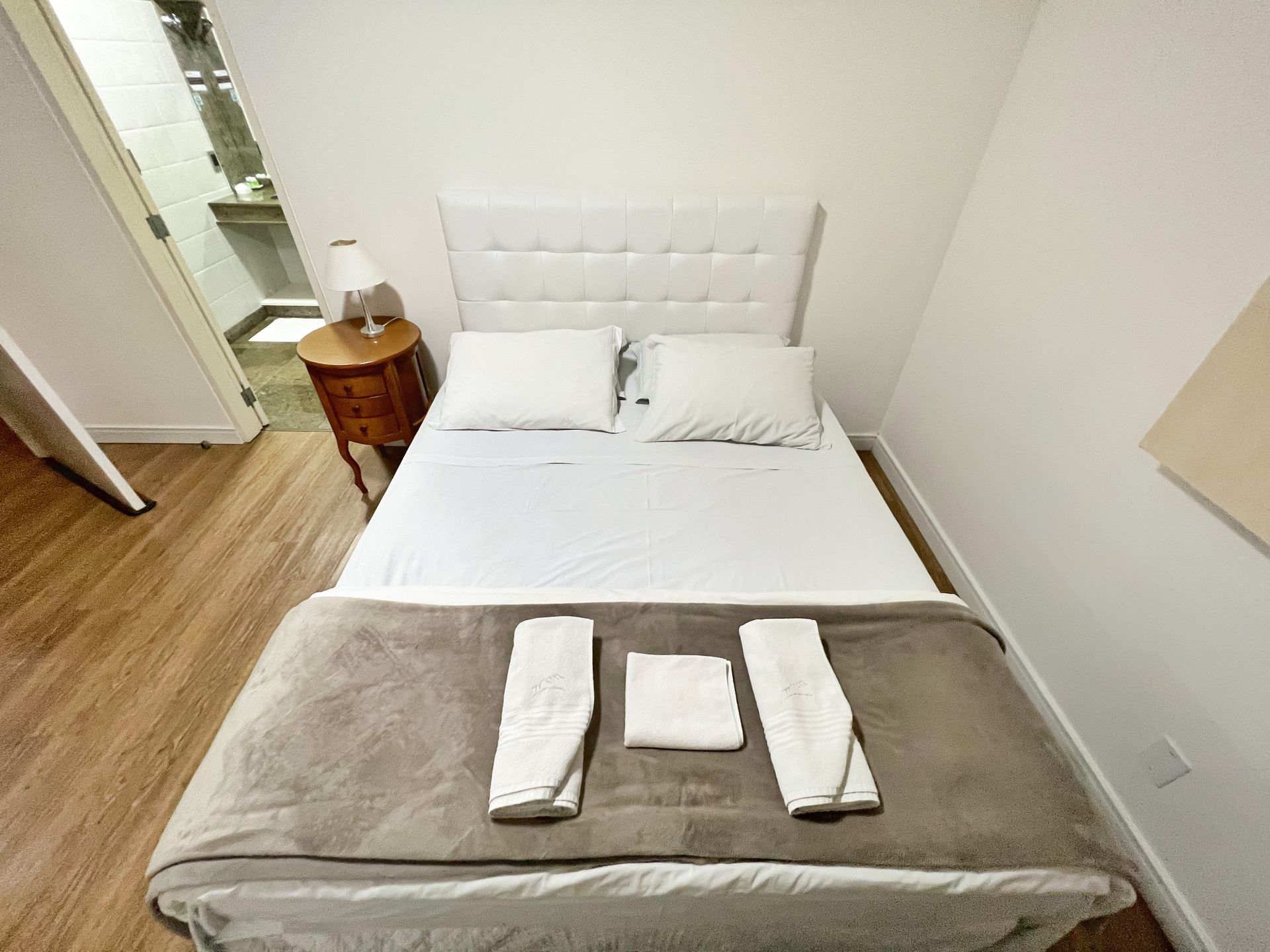 A small bedroom with a bed and two towels on it