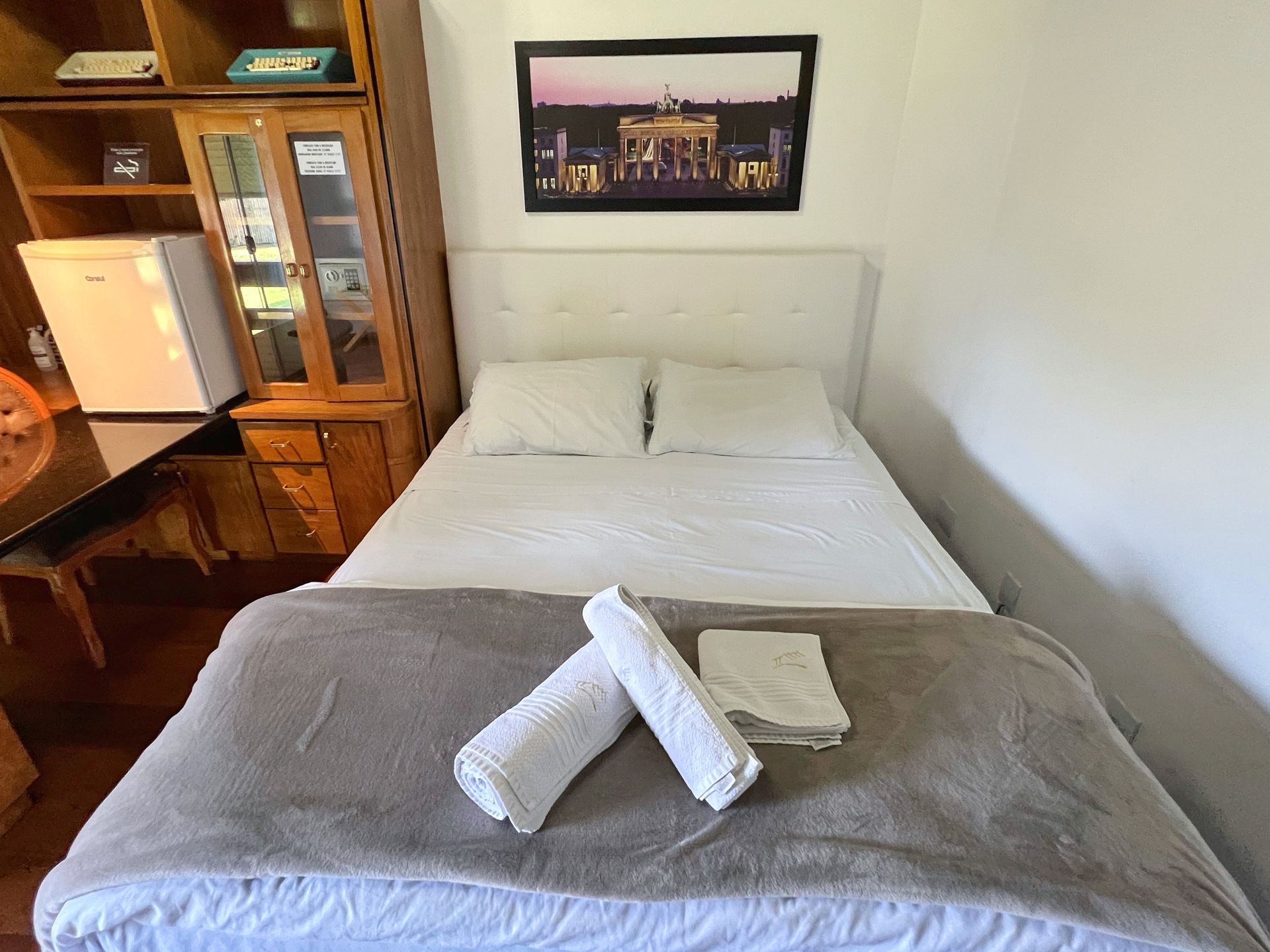 A bedroom with a bed and a picture on the wall