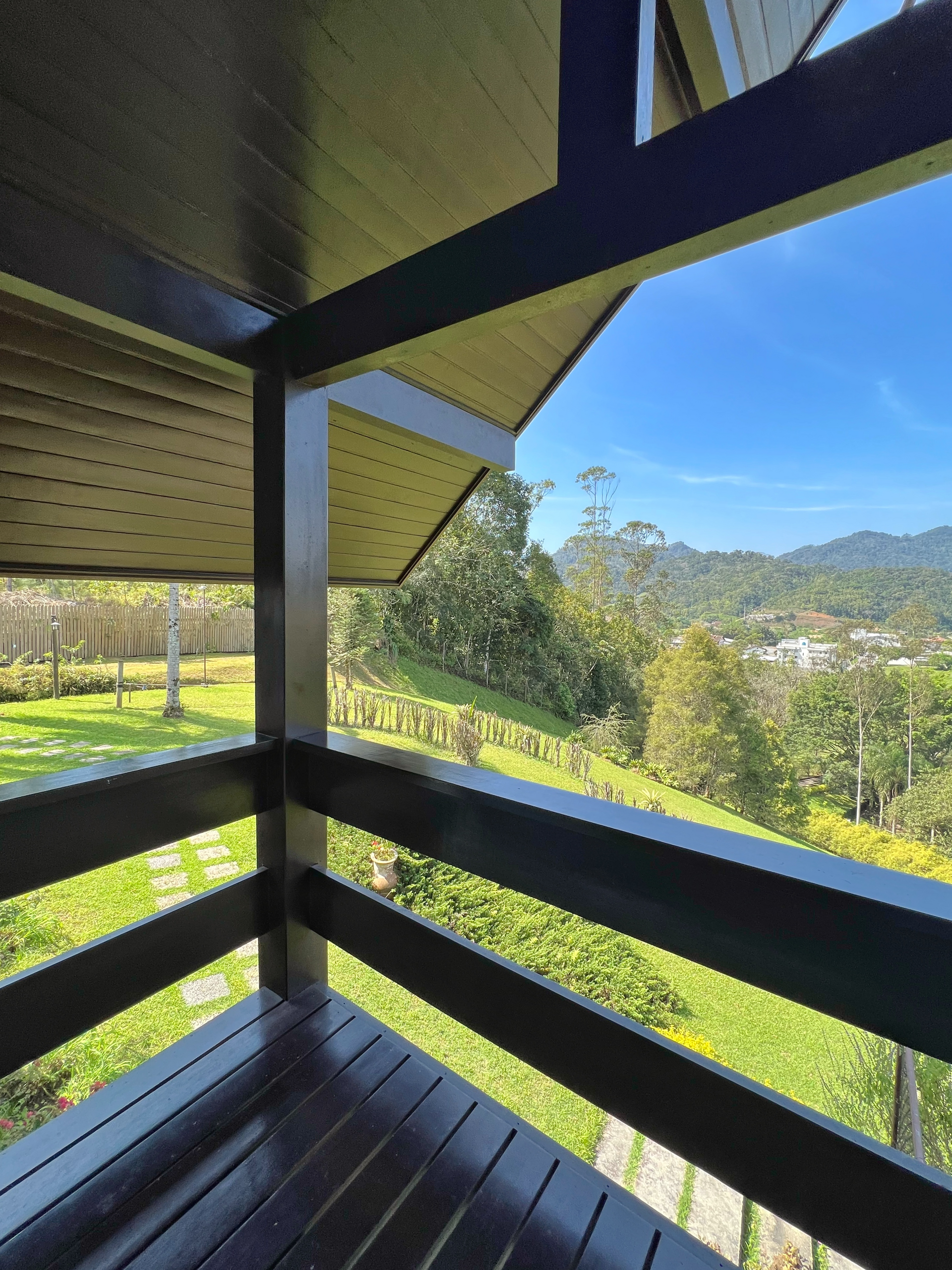A balcony with a view of a lush green hillside