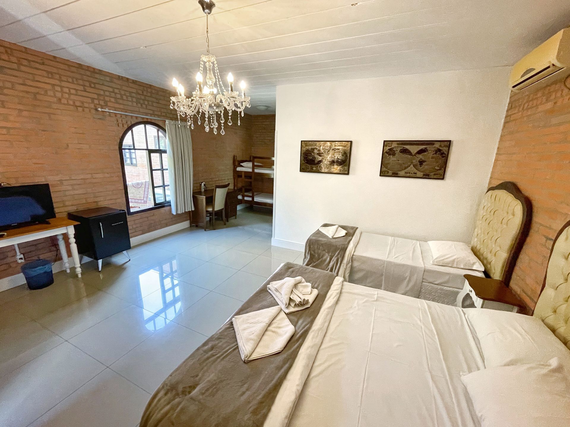 A hotel room with two beds and a chandelier.