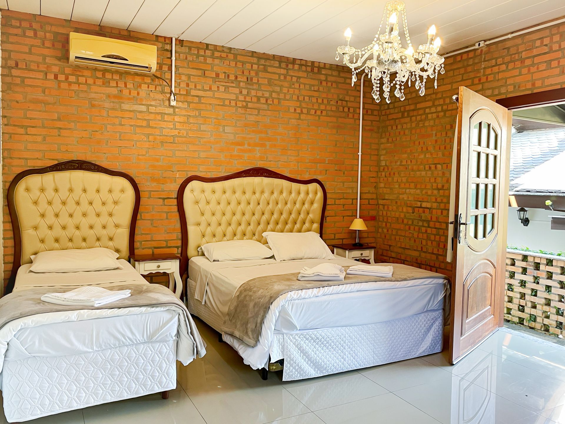 A hotel room with two beds and a chandelier.