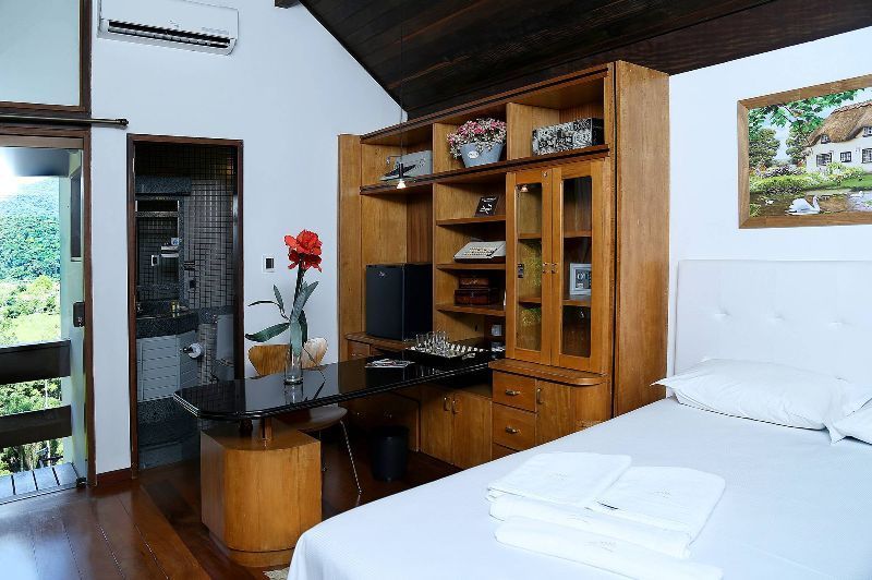 A bedroom with a bed , desk , cabinets and a picture on the wall.