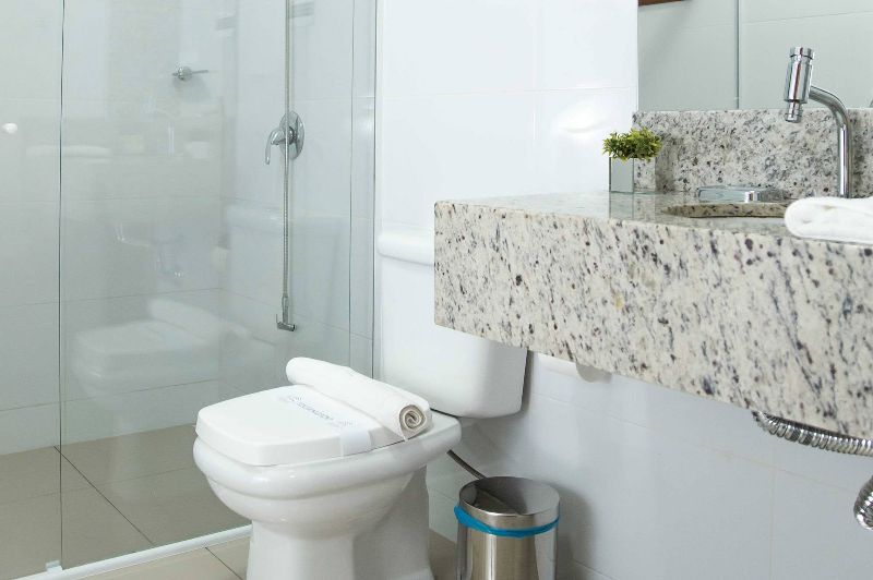 A bathroom with a toilet , sink , and shower.