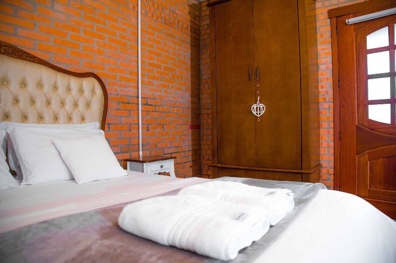 A bedroom with a bed and a brick wall.