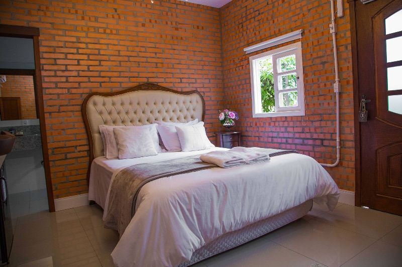 A bedroom with a bed and a brick wall.