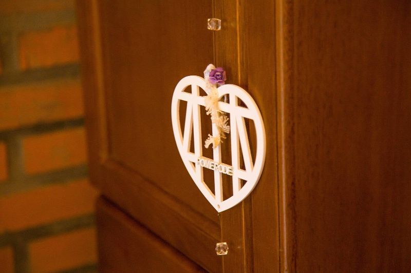 A wooden cabinet with a heart shaped decoration on it.