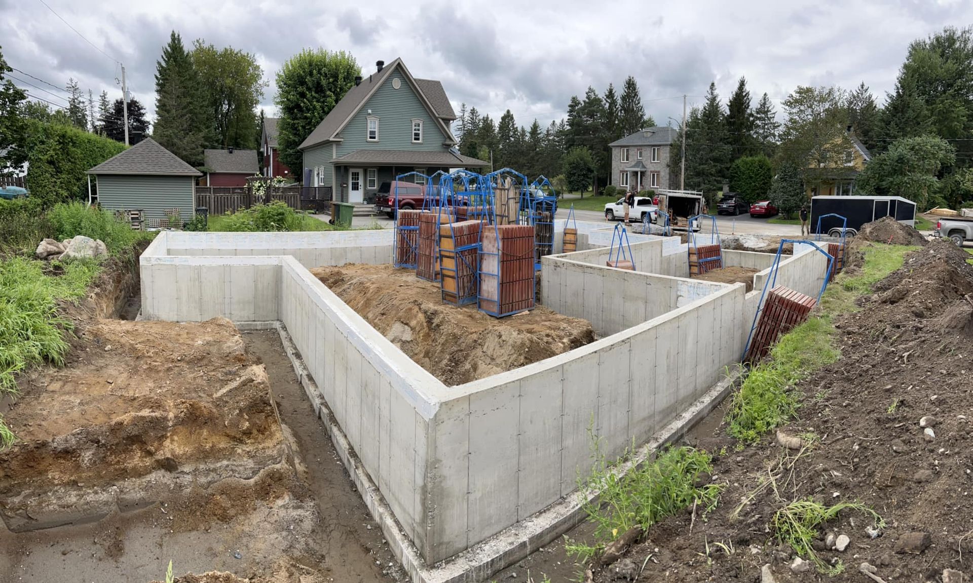 Un grand mur de béton est en train d'être construit devant une maison. Coffrage en béton.
