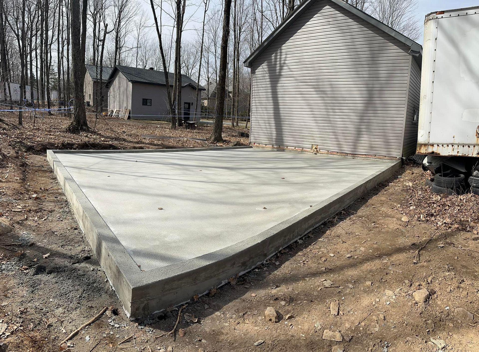 Une allée en béton est en cours de construction devant un garage.