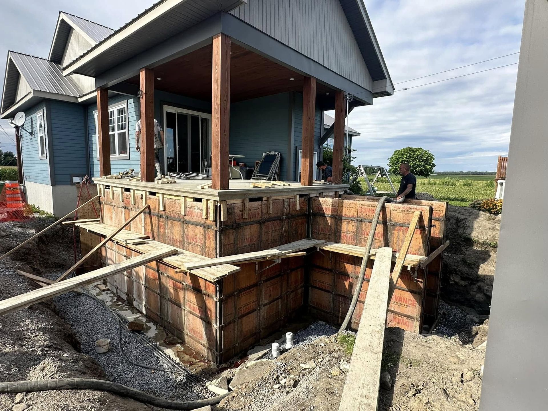 Une maison est en construction au milieu d'un champ de terre.
