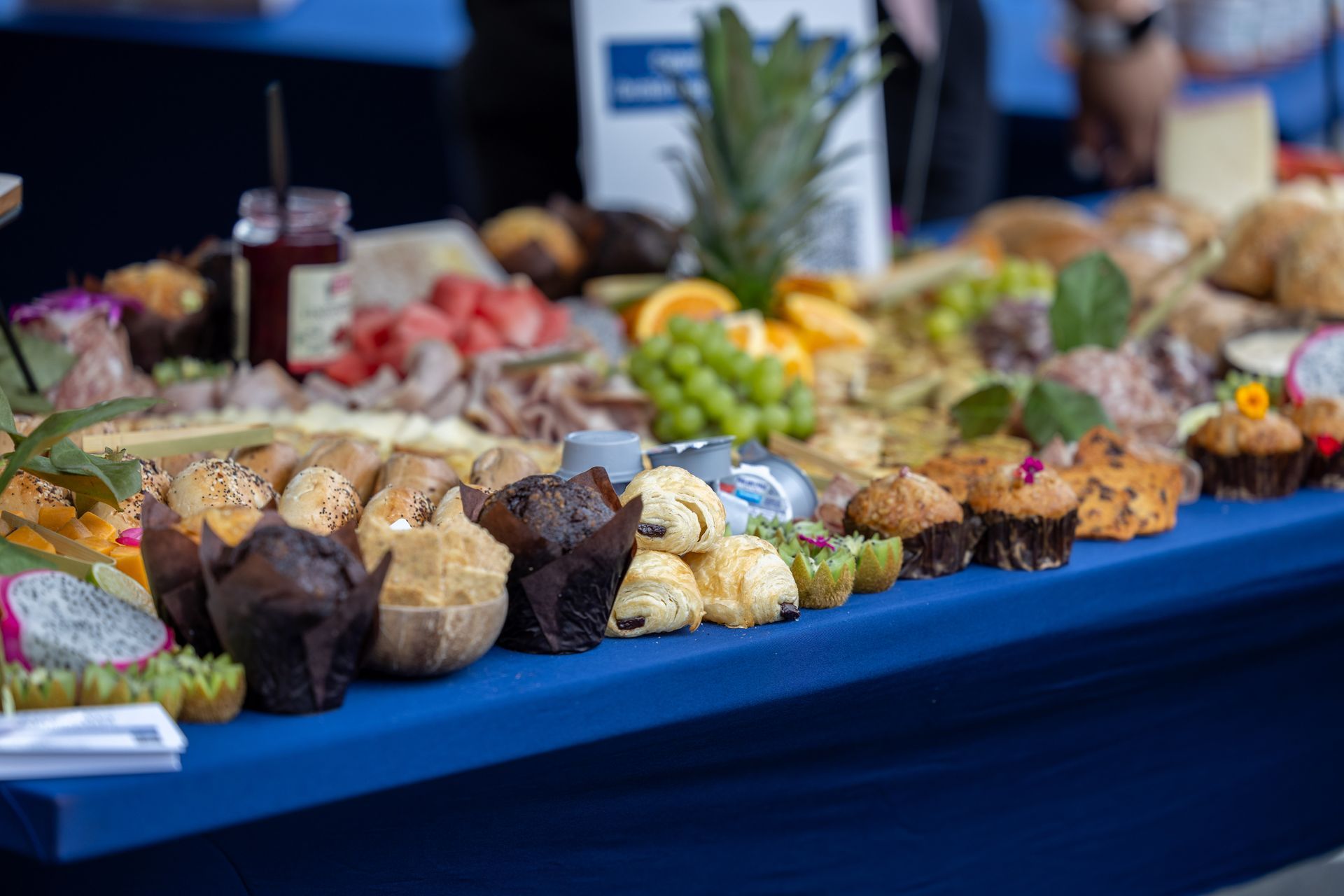 Assorted cupcakes and desserts arranged on a blue-covered buffet table at a party