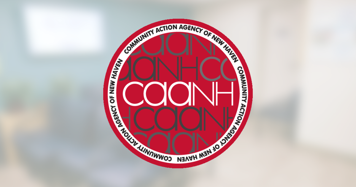 Red circular CAAHN logo centered on a blurred indoor hallway background