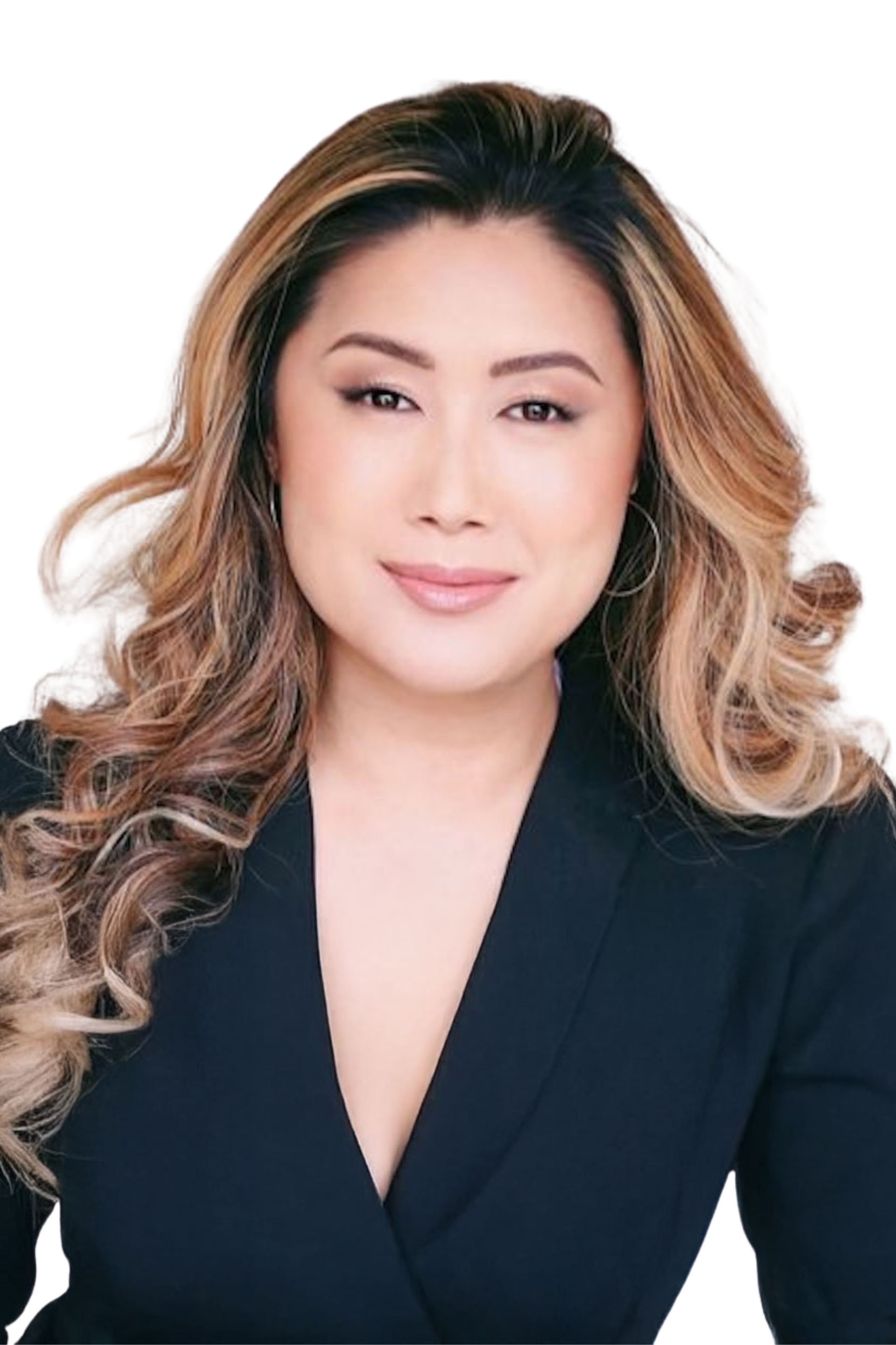 Smiling woman in a black blazer with wavy highlighted hair on a white background