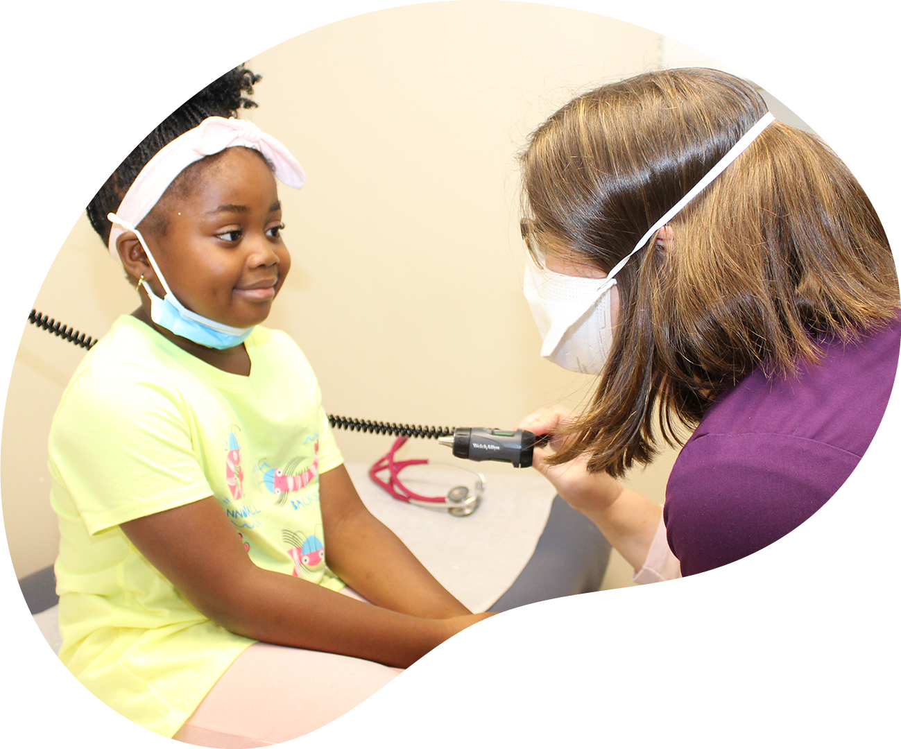 Child receiving a dental exam from a clinician in a treatment room