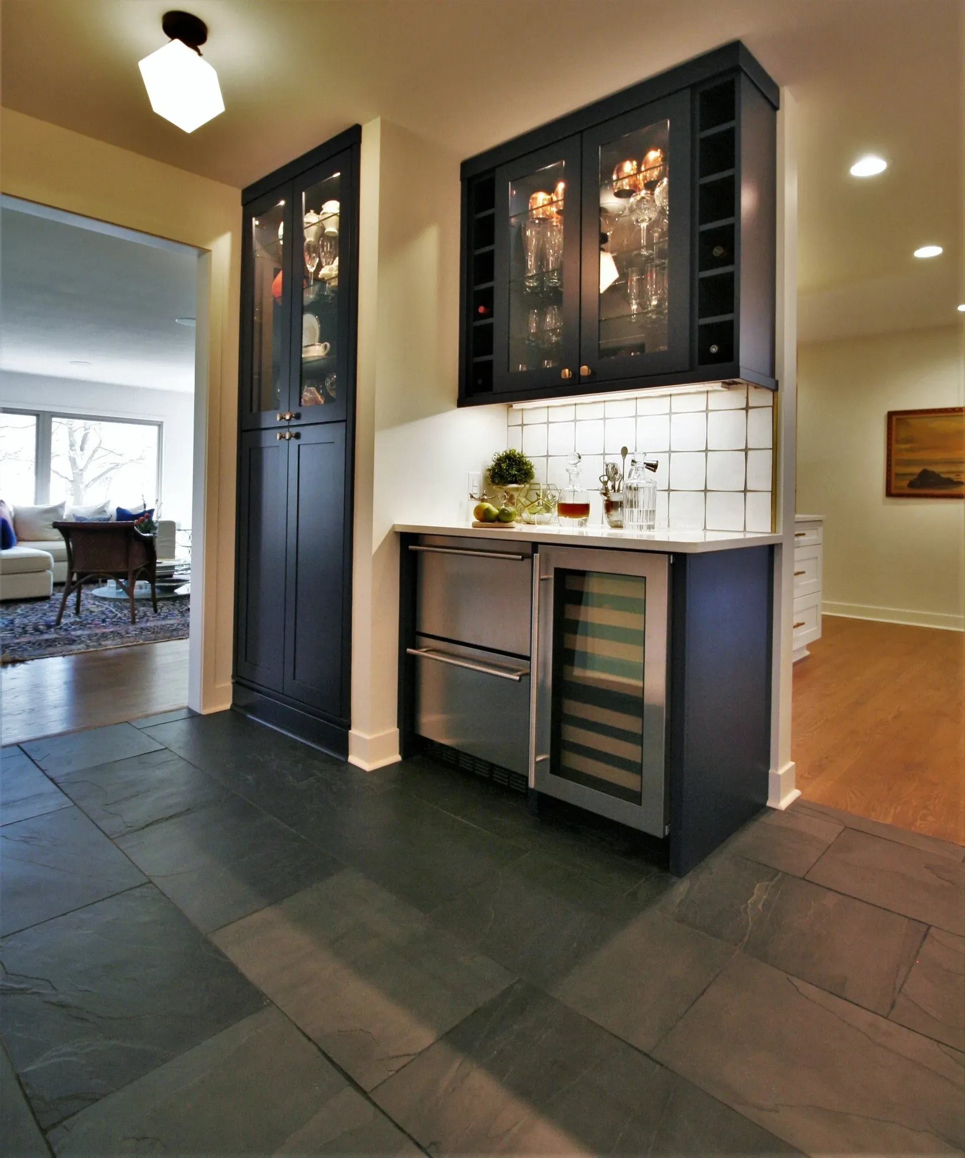 Modern kitchen with dark cabinets, tile floor, and a white countertop in an open home interior