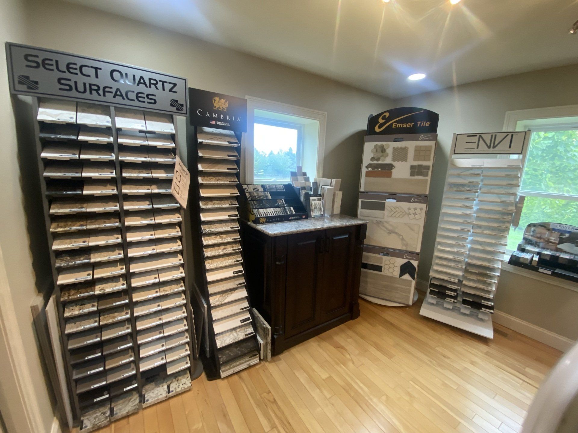 Quartz and surface samples displayed in a showroom with wood floors and display racks