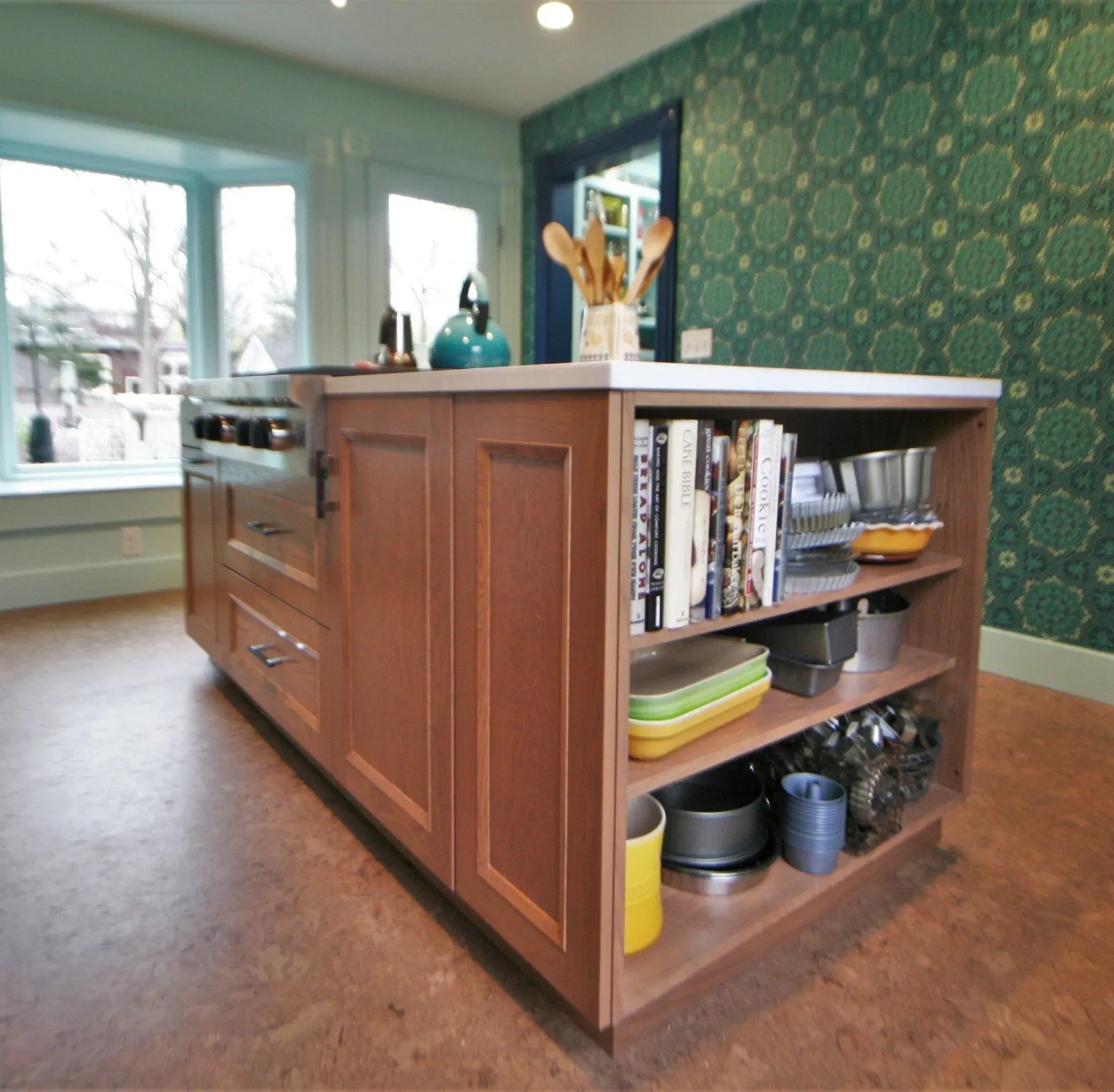 Modern kitchen with a wood island, open shelves, and green patterned wallpaper