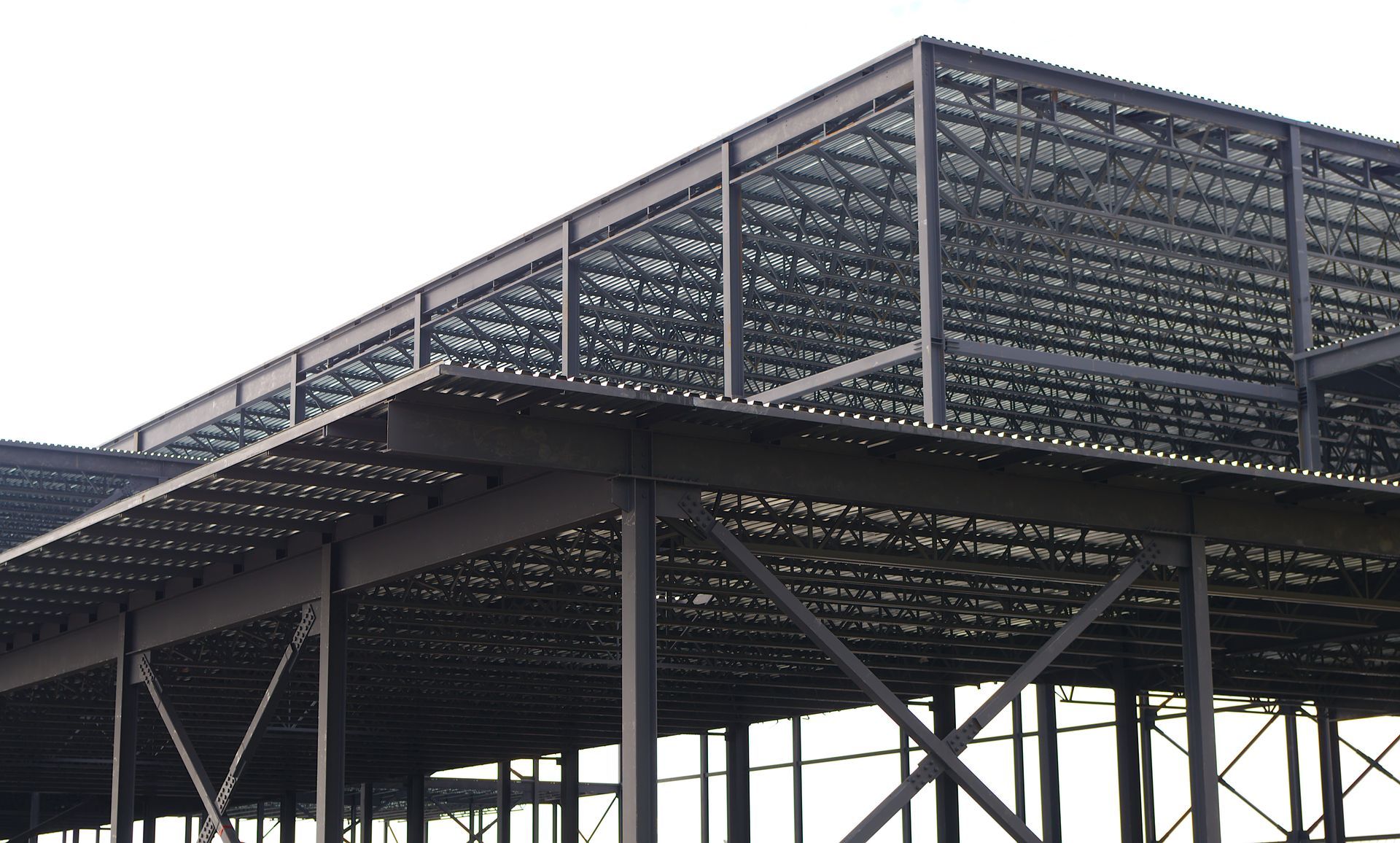Modern steel-framed building with open lattice roof and dark support columns