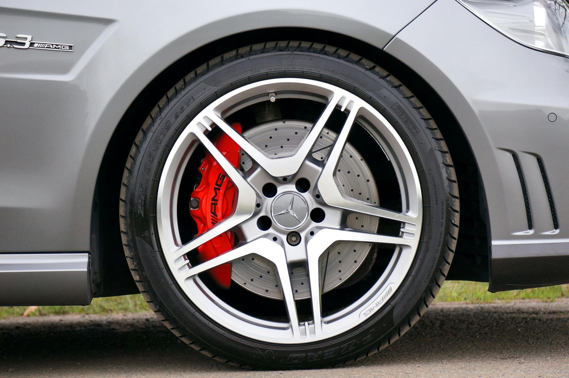 Silver car wheel with red brake calipers | Action Service Center