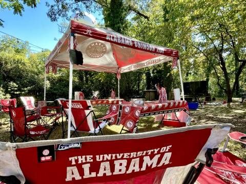 The university of alabama is displayed on the back of a red chair.