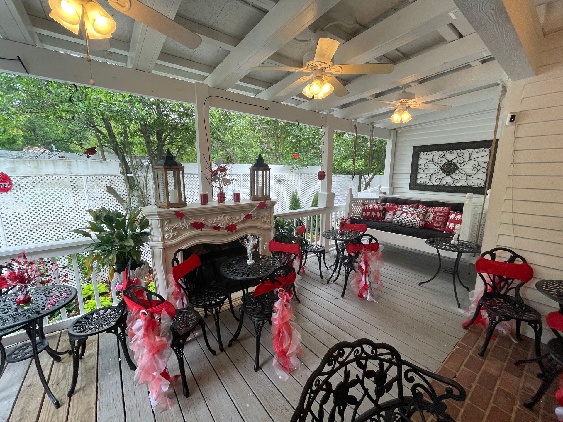 A room with tables and chairs decorated with red ribbons.