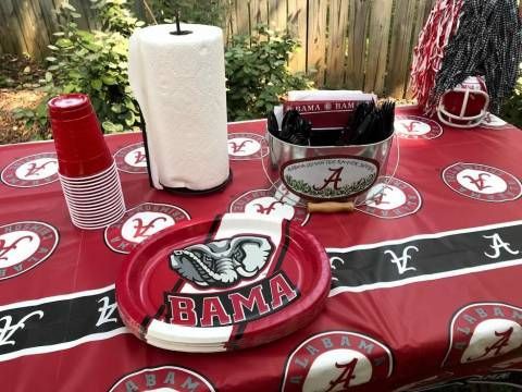 A table with plates , cups , paper towels , and a bowl on it.
