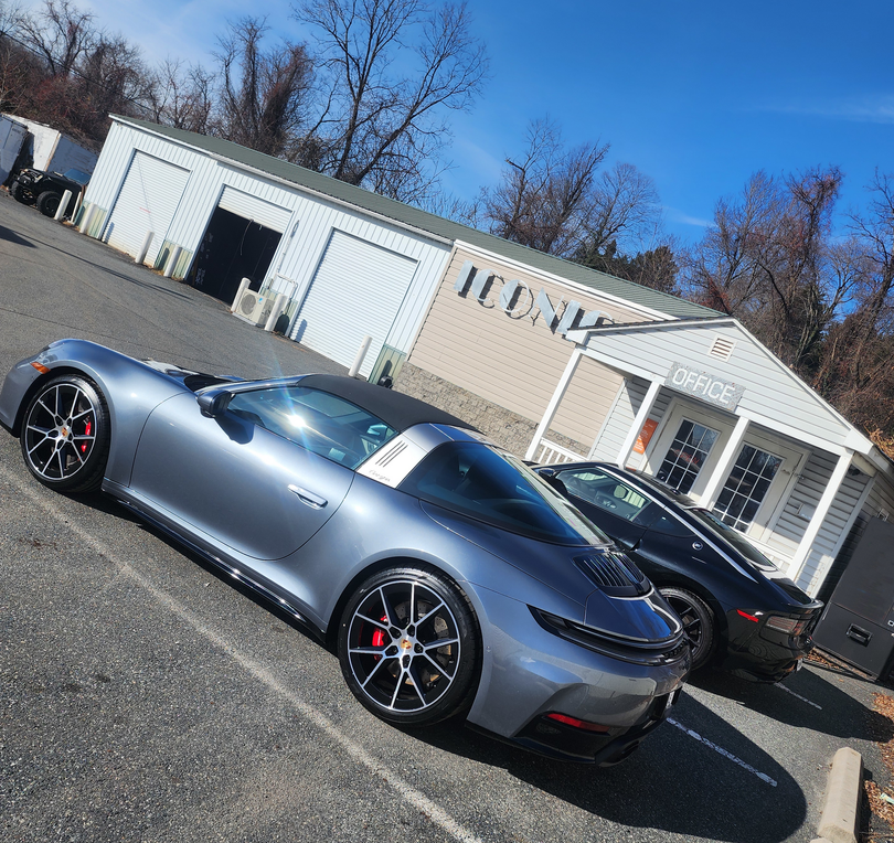 Silver sports car parked outside a building on a sunny day