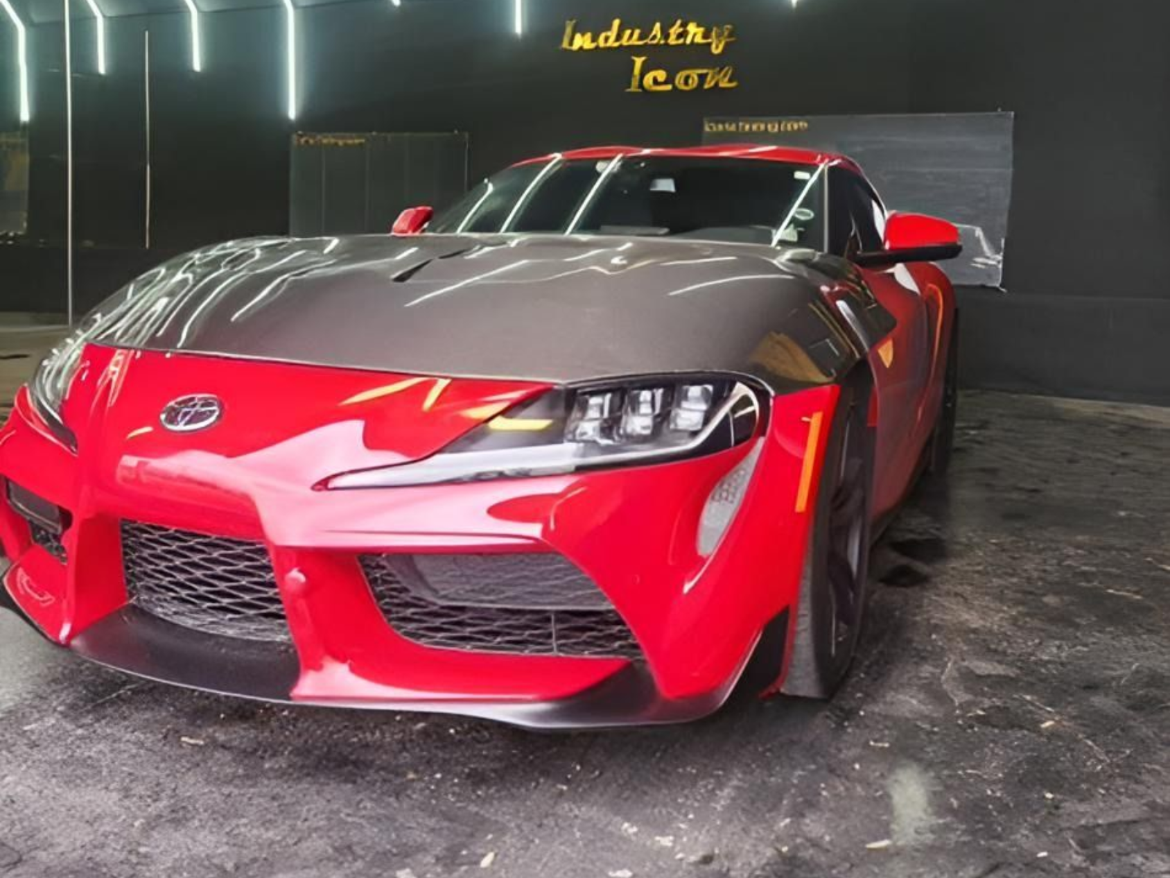 Red sports car with black hood in a showroom under neon lights