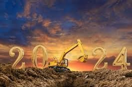 A yellow excavator is sitting on top of a pile of dirt.